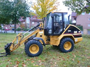 Kompakter CAT-Radlader auf einer Wiese